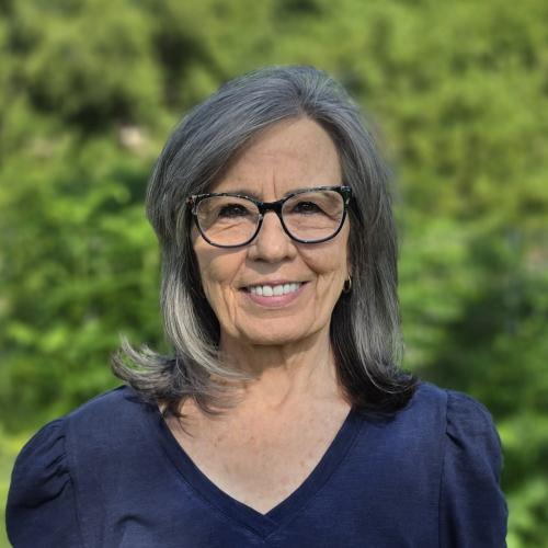 A photo of Michelle Damvar with greenery on the background